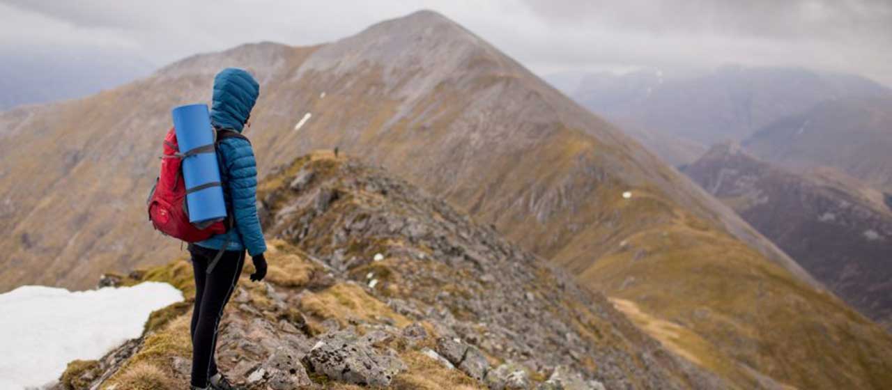 Woman hiking and overlooking mountain